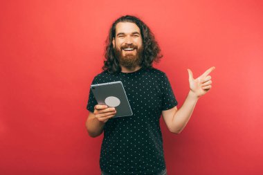 A man holding  new tablet and at the same time pointing at a free space