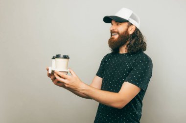 A picture of a delivery guy delivering two cups of coffee to someone