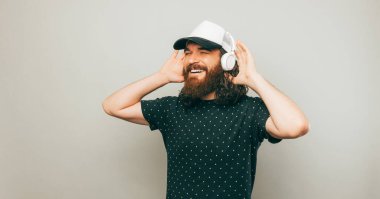 A bearded young man is happily listening to his music