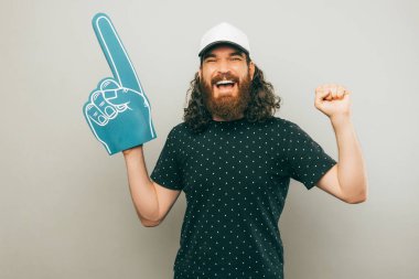 A man with a fan glove is hyping his favorite soccer team