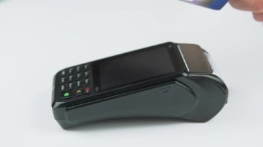 Close up video of male hand paying with card at terminal.