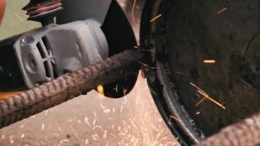 footage of male master in red working with a grinding machine for cutting metal.