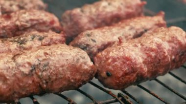 Close up footage of preparing meet sausages at grill outdoors.