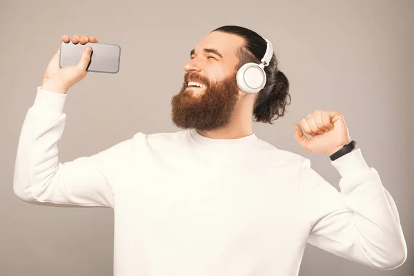 Relaxed Young Man Wearing White Sweatshirt Headphones Holding Phone Enjoys —  Fotos de Stock