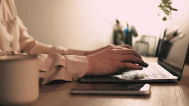 footage of office woman worker using laptop on table during night time.