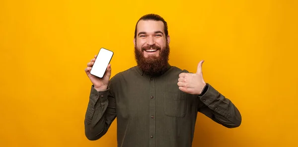 Ecstatic Bearded Man Shows Phone Screen Camera Thumb Studio Shot — Fotografia de Stock
