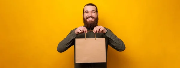 Excited Man Showing Camera Craft Shopping Bag Copy Space Studio — стоковое фото