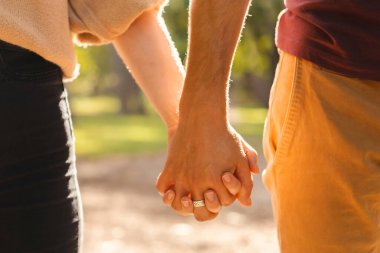 Beraberliğin yakın çekimi. Adam gün ışığında kadınını tutuyor..