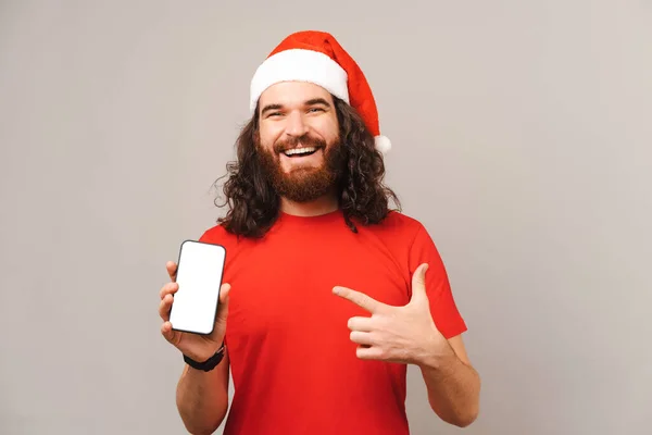 Εκστατικός Γενειοφόρος Χριστουγεννιάτικος Άντρας Δείχνει Την Οθόνη Του Τηλεφώνου Και — Φωτογραφία Αρχείου