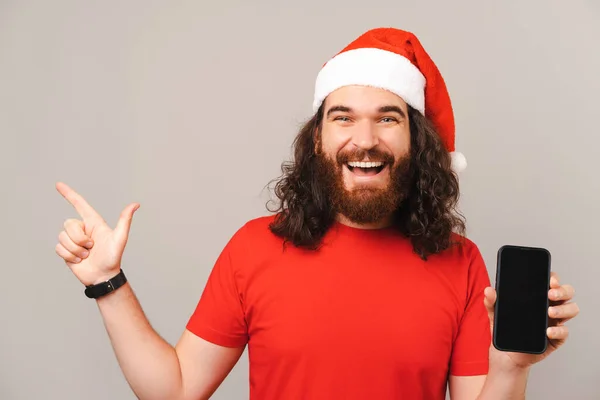 Ενθουσιασμένος Γενειοφόρος Άντρας Των Χριστουγέννων Δείχνει Την Οθόνη Του Τηλεφώνου — Φωτογραφία Αρχείου