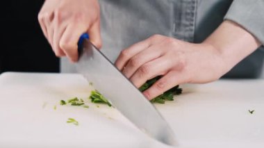 Mutfaktaki beyaz tahtada maydanoz doğrayan şefin videosunu kapat..