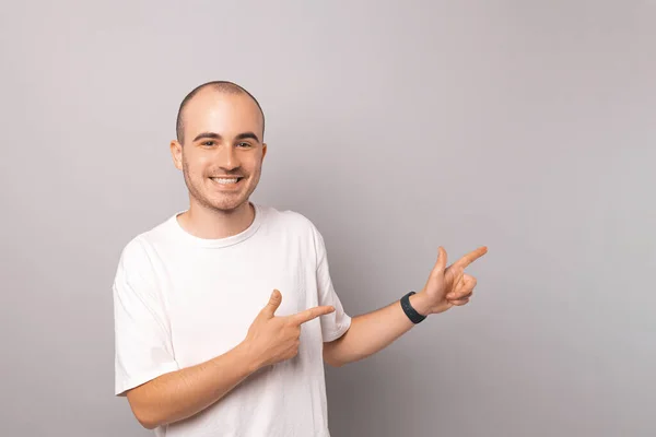 Jovem Careca Feliz Vestindo Camiseta Branca Está Apontando Para Lado — Fotografia de Stock