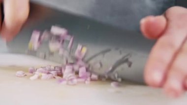 Beyaz masada soğan soğanı doğrayan şefin görüntülerini kapat..