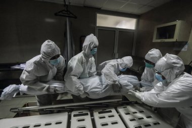 Kişisel koruyucu ekipman kullanan sağlık görevlileri, 16 Temmuz 2021 'de Bogor, Endonezya' daki bir hastanede ölen Covid-19 kurbanının cesedini kapatırken görüldü. Endonezya, Asya 'nın yeni Covid-19 merkez üssü olarak Hindistan' ı ele geçirdi.