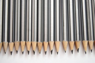 Ofis malzemeleri. Beyaz hasır sepetteki gri kalemler.