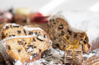 Geleneksel Noel arkaplanda mumlarla süslenmiş kurutulmuş meyve ve fındıklardan yapılmış pudra şekeri serpiştirilmiş. Geleneksel Noel keki.