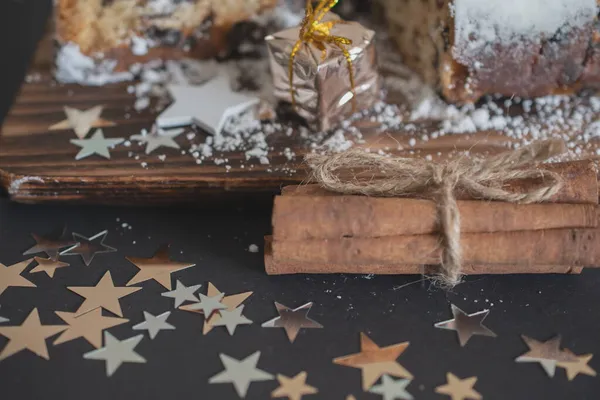 伝統的なクリスマスは ろうそくのあるクリスマスの装飾の背景に粉砂糖を振りかけたドライフルーツとナッツで作られた盗まれた 伝統的なクリスマスカップケーキ — ストック写真