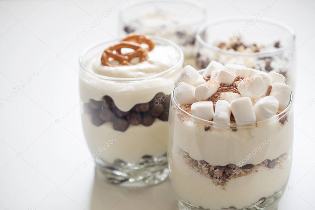 Delicious sweet dessert with cream in a glass on a light background, a beautiful breakfast