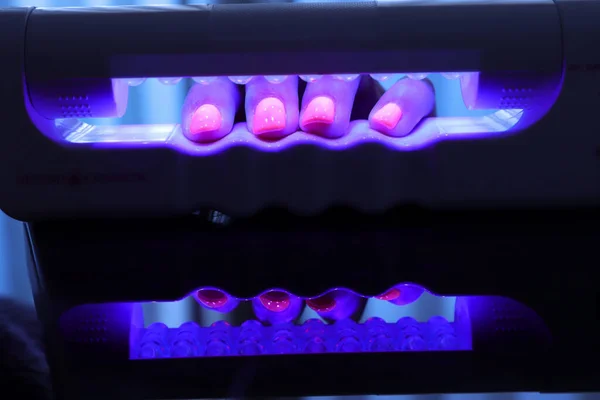 Fotoğrafçılık polarize ultraviyole lamba ile manikür yapıyor.