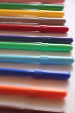 Üst üste beyaz bir arka plan üzerinde renkli kalemler