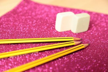 colorful felt-shaped paper and pencil with christmas decorations on wood background