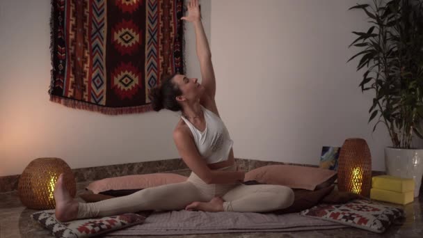 Mujer joven disfruta del yoga en Forward Bend posan sobre alfombra en casa — Vídeos de Stock