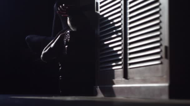 Чоловік спить в кріслі і рука спить над краєм в темній кімнаті — стокове відео
