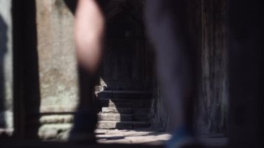 Gezgin, Angkor Wat Tapınağı 'nın boş kemer koridorunda yürüyor.