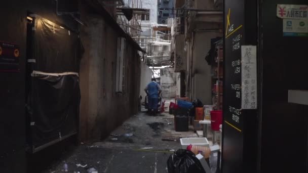 ごみのある貧しい地区の暗い通りに沿ってトラックで歩く人 — ストック動画