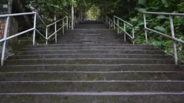 Parkta metal tırabzanlar olan uzun gri merdivenler.