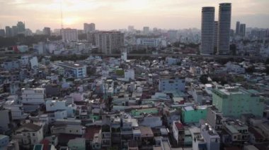 Büyük gökdelenleri çevreleyen farklı küçük binalar. Ho Chi Minh Şehri, Vietnam.