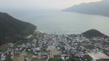Kahverengi tarlalar ve binalar Khanh Hoa Vietnam 'da deniz ve tepeler arasında yer alıyor.