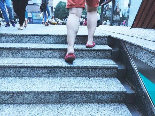 legs of a man walking on the stairs