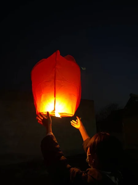 woman holding lantern with burning candle