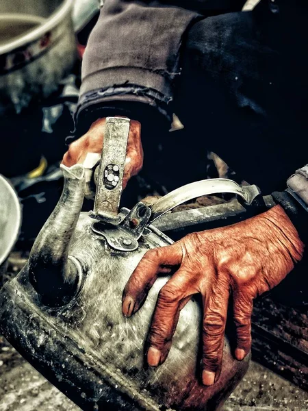 blacksmith working with a metal chain