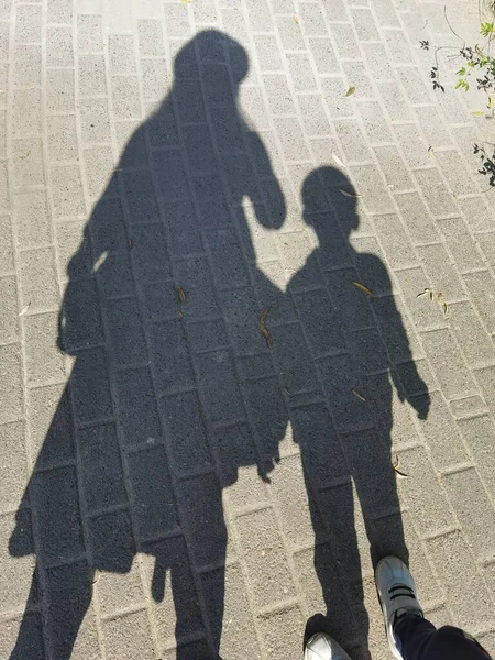 silhouette of a man and woman walking on the street