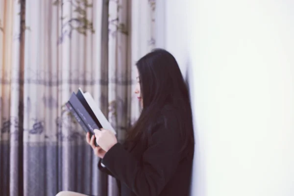 young woman reading book in the room