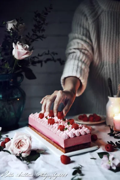 a woman with a cake and a cup of tea