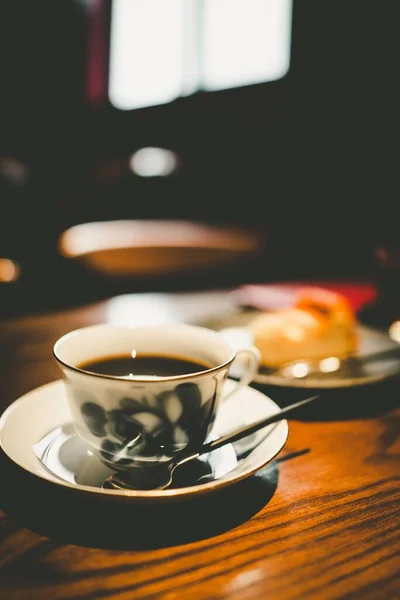 cup of tea with lemon and coffee on wooden table