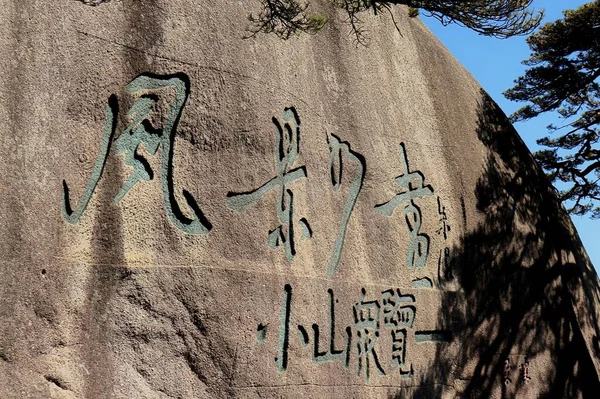 a closeup shot of an ancient egyptian hieroglyphs and graffiti on a rock in the park on the background of