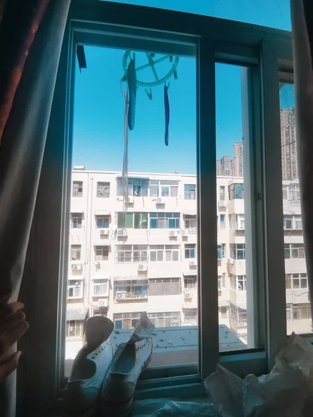 young woman sitting on the windowsill and looking at the window