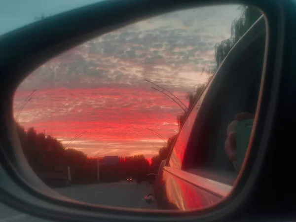 car window with red and white clouds