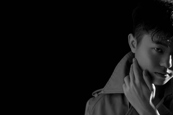 young man with a black hair on a dark background