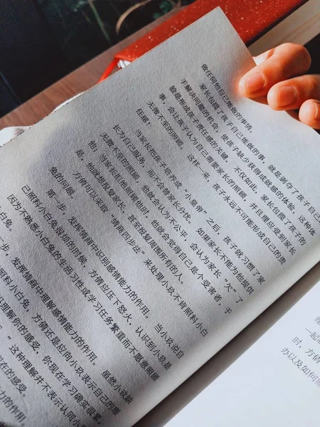 close up of a person\'s hand writing on a book