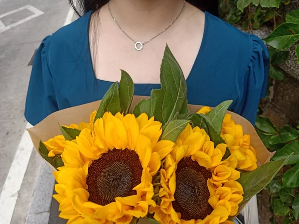 beautiful young woman with bouquet of sunflowers