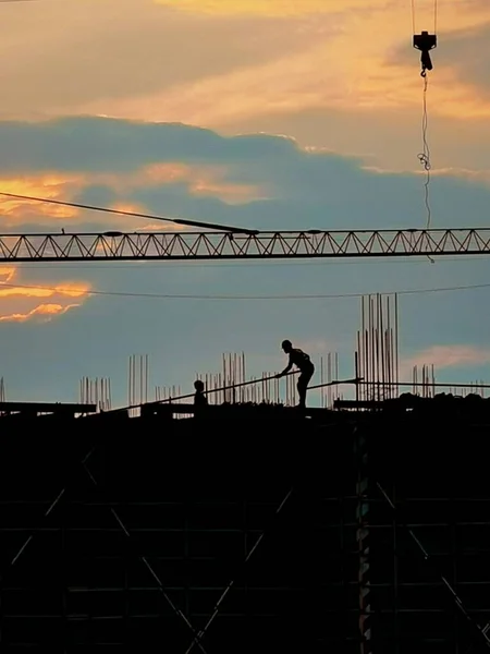 silhouette of a construction crane on a building