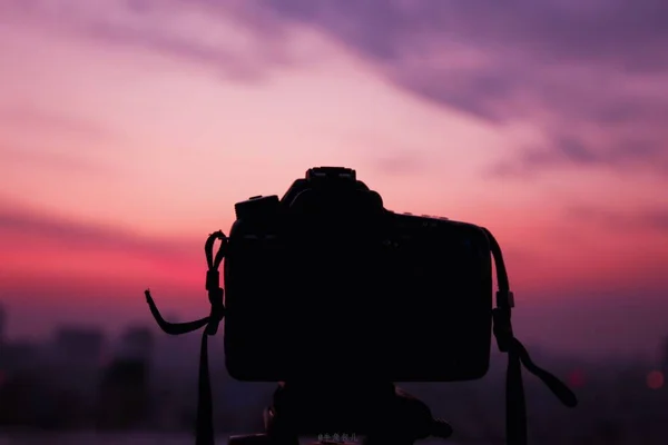 silhouette of a photographer with a camera on the background of the sunset