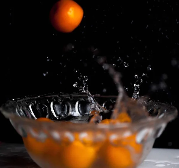 fresh orange juice with water splash on black background