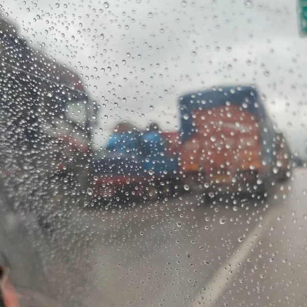 car window with rain drops on the street