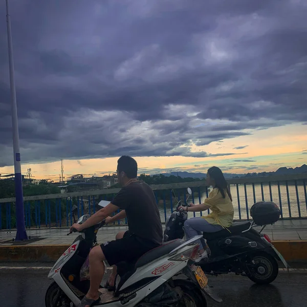 young couple riding a motorcycle in the city